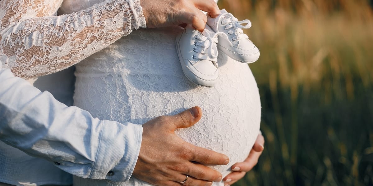 Femeie tânără care își planifică pregătirea preconcepțională cu un caiet și o ceașcă de ceai