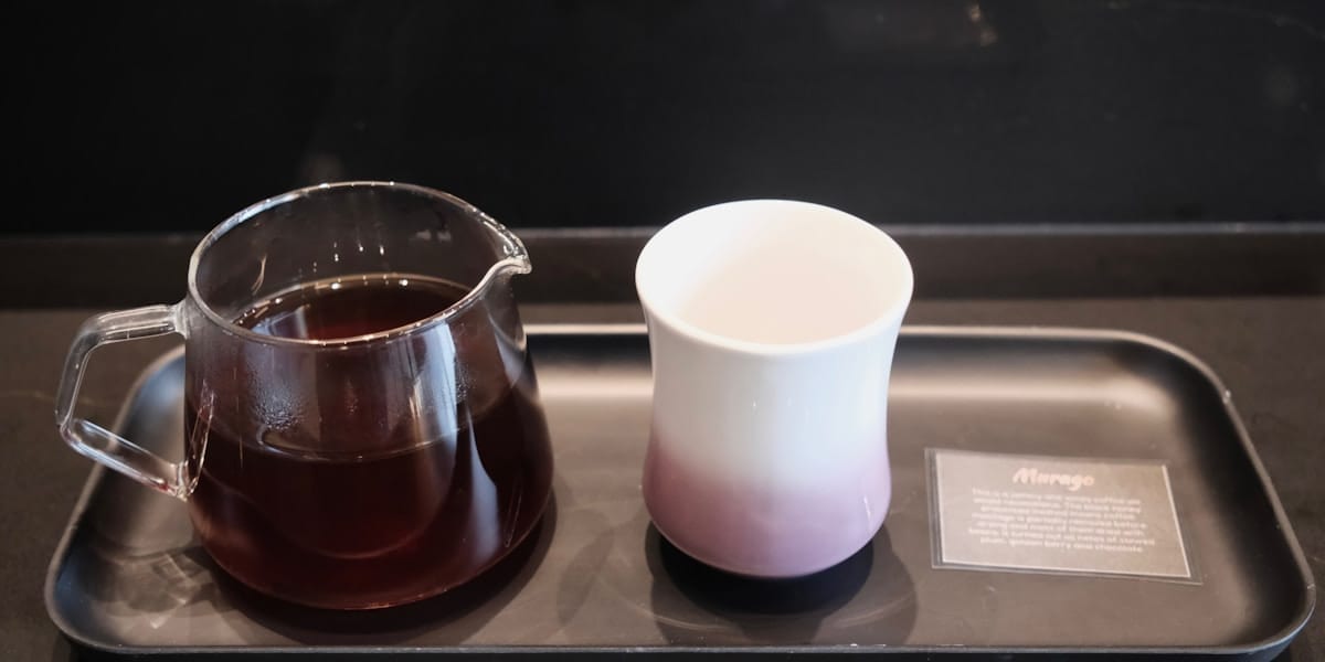 Ceașcă de cafea proaspăt măcinată pe blatul bucătăriei, în lumina blândă de dimineață