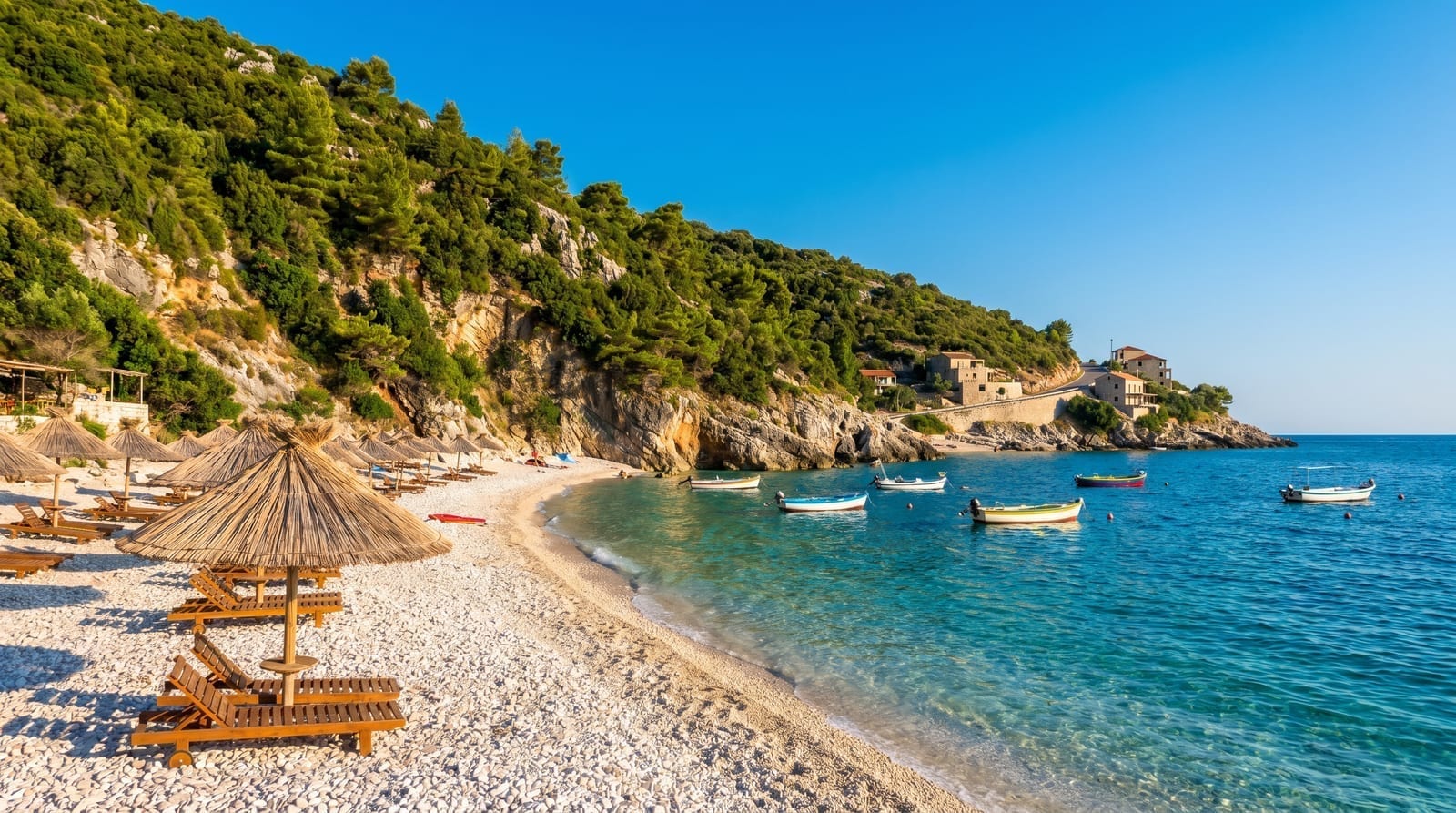 Plajă cu apă turcoaz și insulițe mici la Ksamil, una dintre cele mai frumoase stațiuni pentru o vacanță în Albania