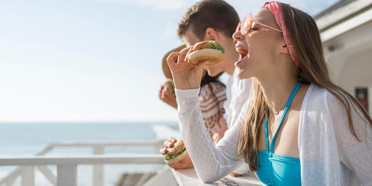 Masă de vară pe terasă cu salată, fructe și un pahar cu apă, alegeri culinare echilibrate în vacanță
